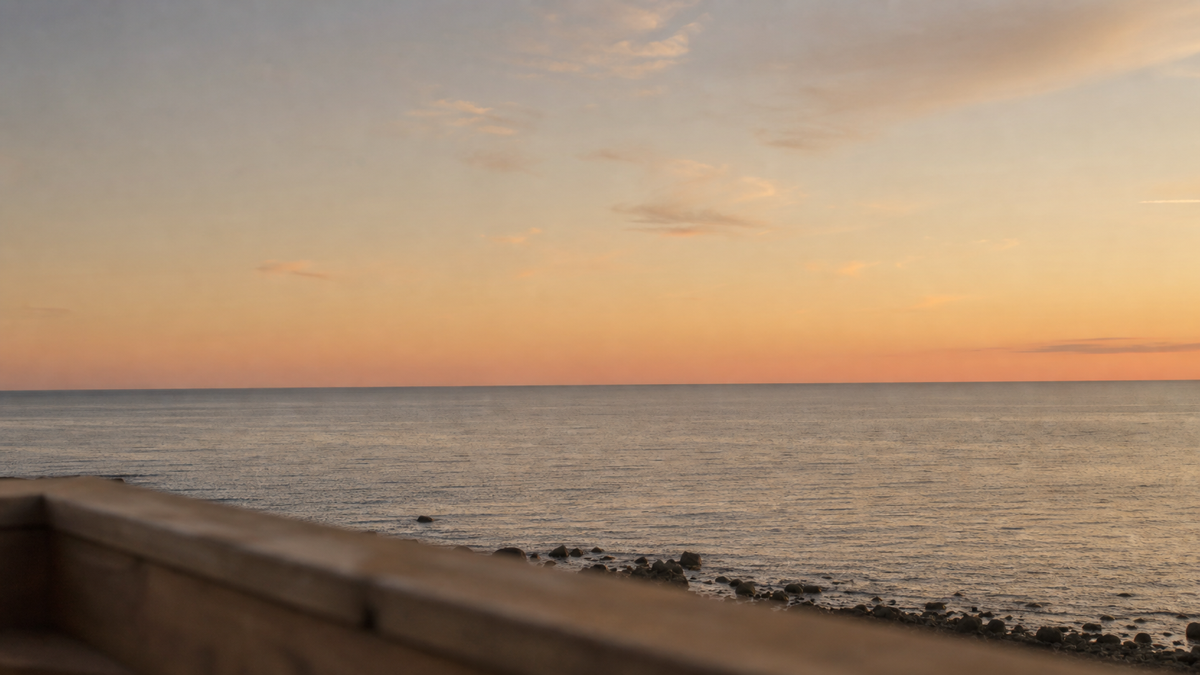 湯船の縁越しに見える海と夕景