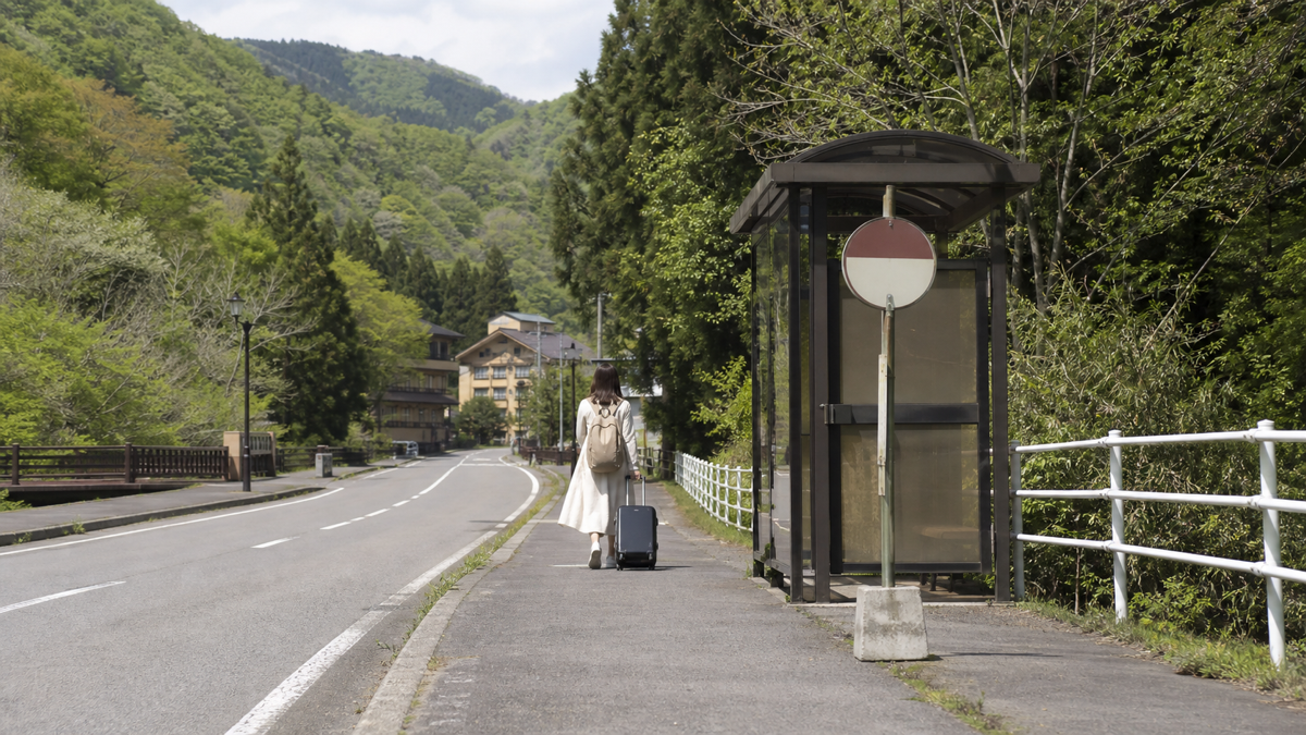 バスを降りて緑道を歩き温泉施設へ向かう車なし旅のイメージ
