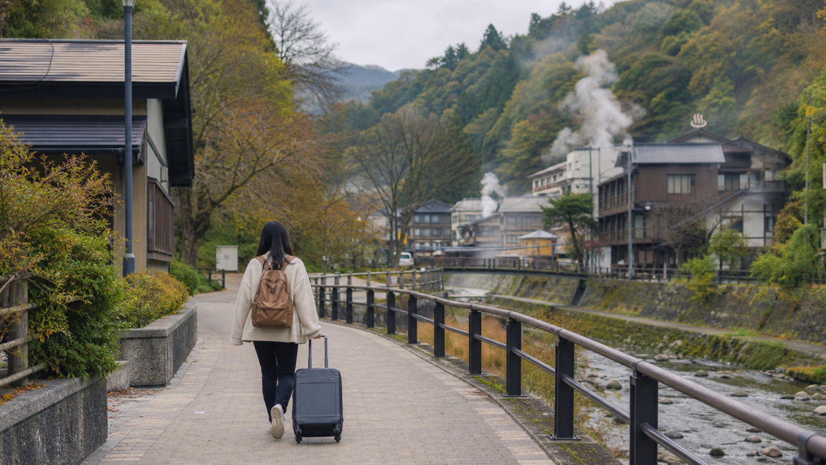 駅から徒歩で温泉街へ向かう旅行者のイメージ